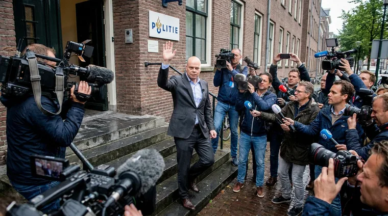 Bouman komt het politiebureau uit, pers en camera's om hem heen